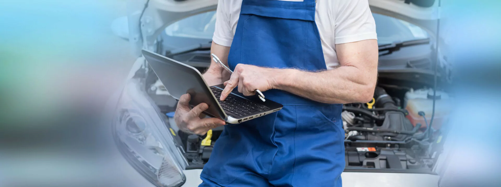 Mechanic Using Laptop For Checking Car Engine